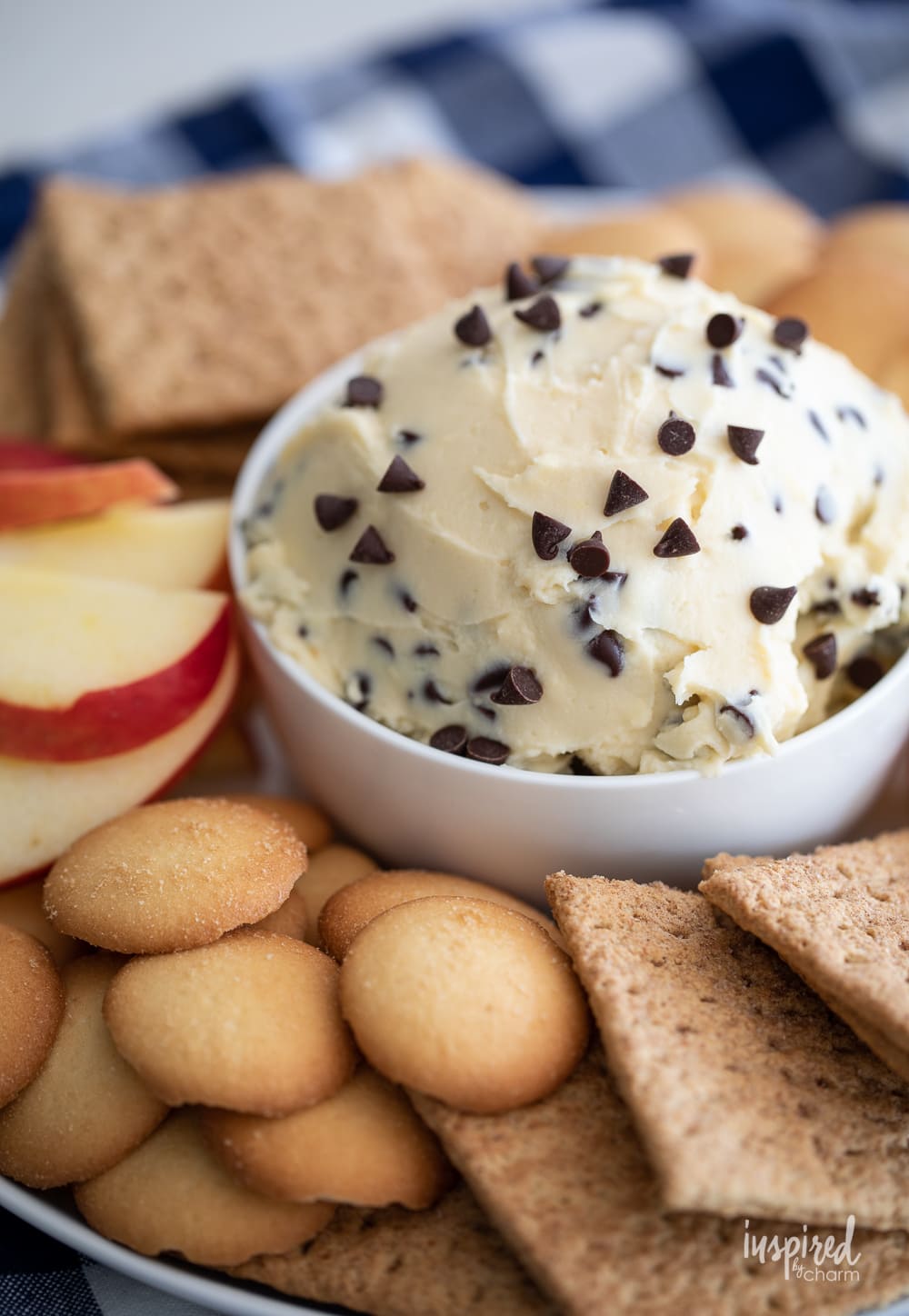 chocolate chip cheesecake dip in a bowl with cookies and apple slices. 