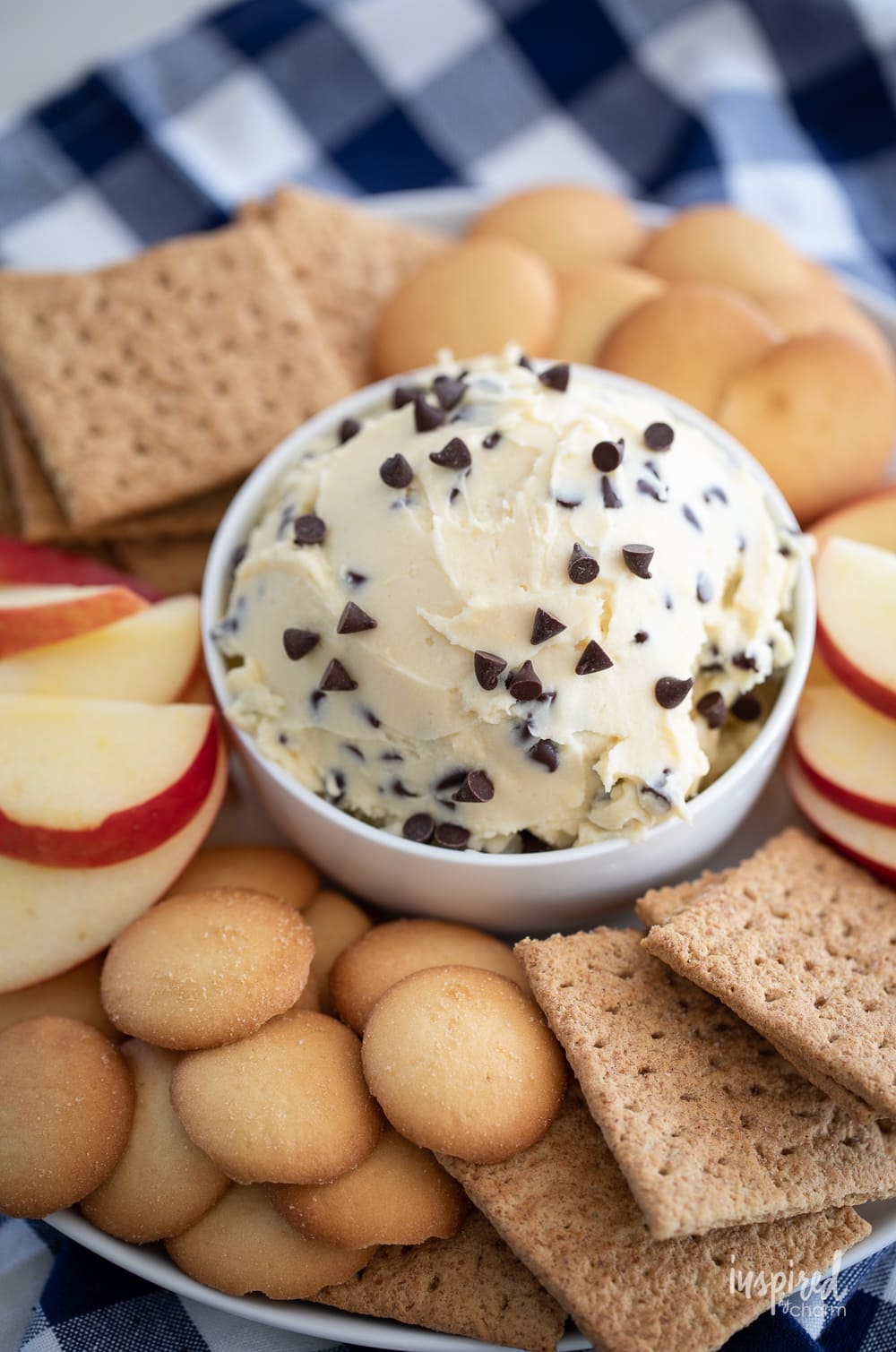 chocolate chip cheesecake dip in a bowl with cookies and apple slices. 