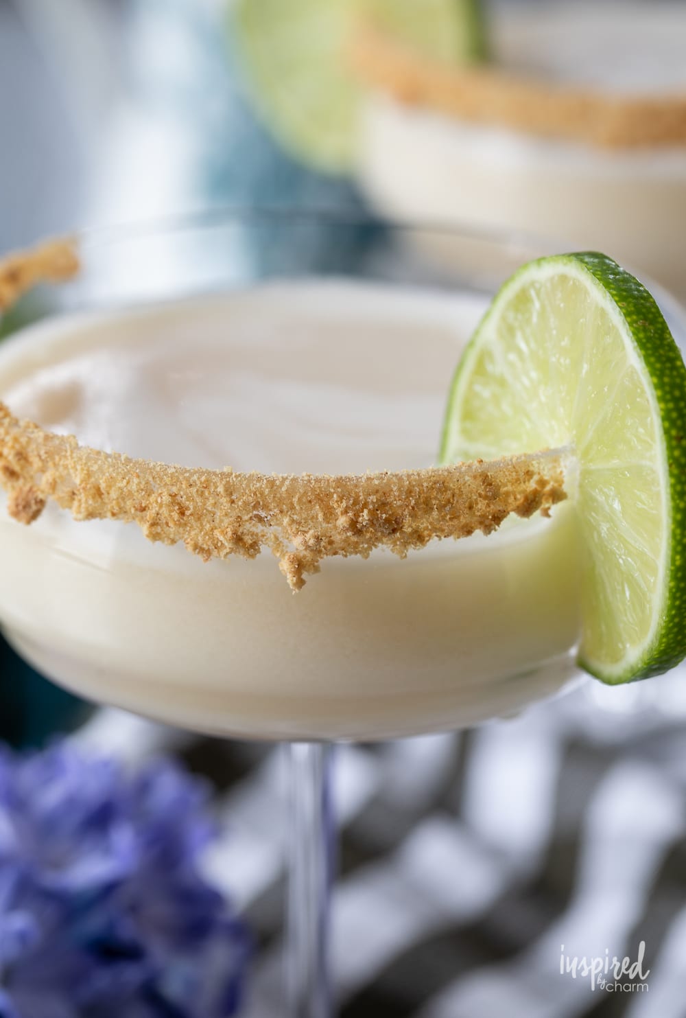 close up of key lime pie martini in a glass with a lime garnish.