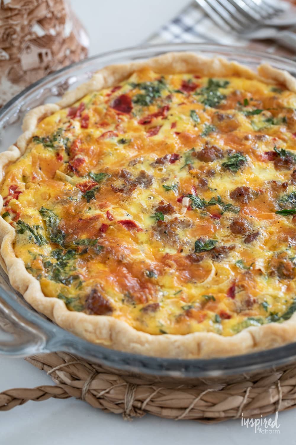 red pepper and sausage quiche in a clear pie plate. 