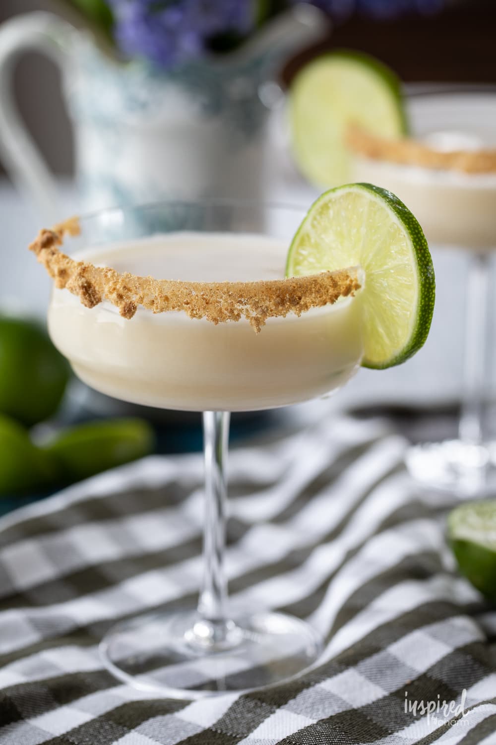 key lime pie martini in a glass with a lime garnish.