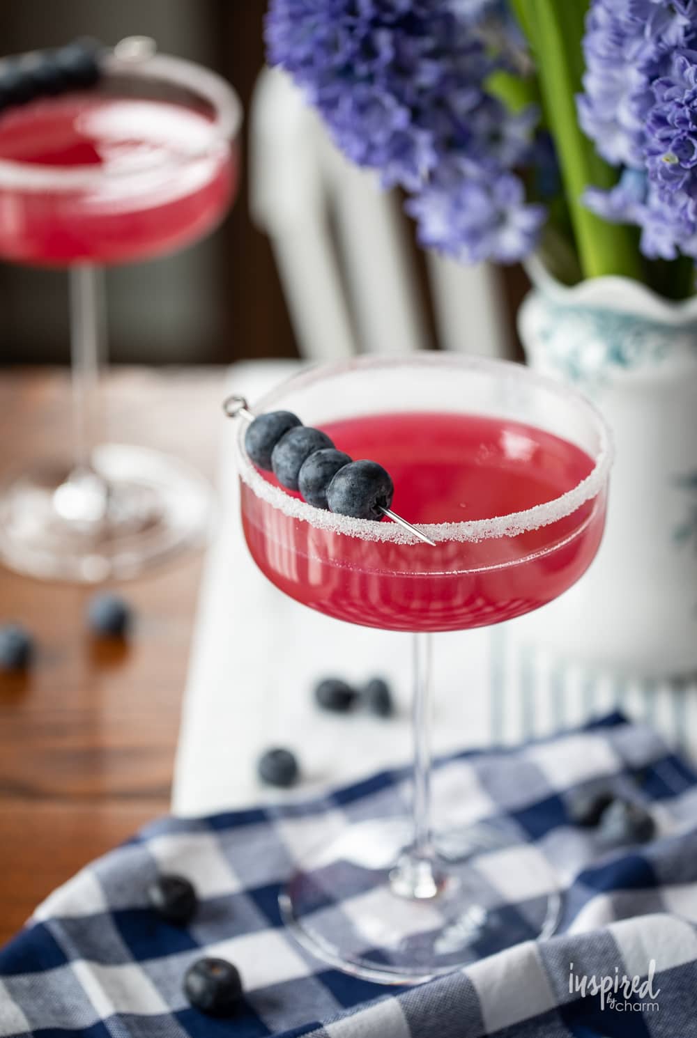 blueberry lemon drop martini in glass with blueberry garnish. 