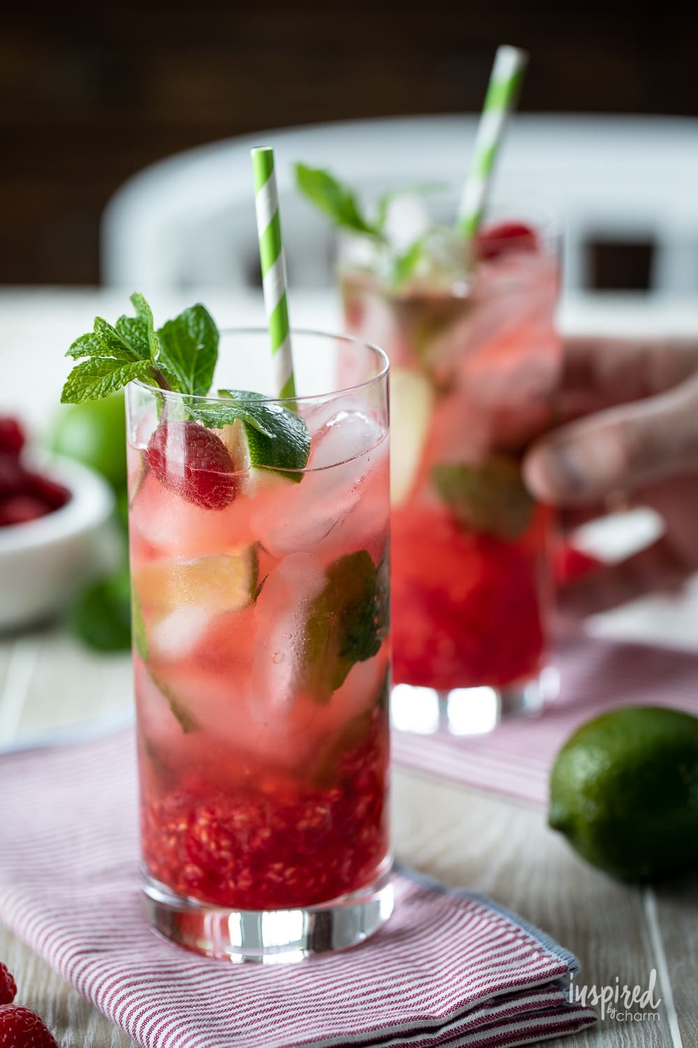 raspberry mojitos with hand holding one.