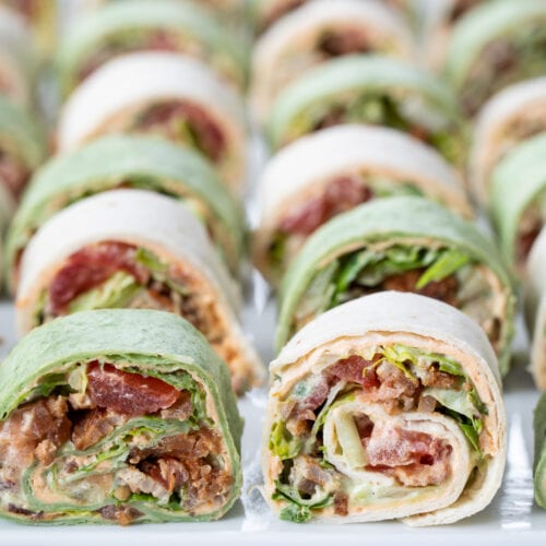 BLT Pinwheel Sandwiches lined up and displayed on a large platter.