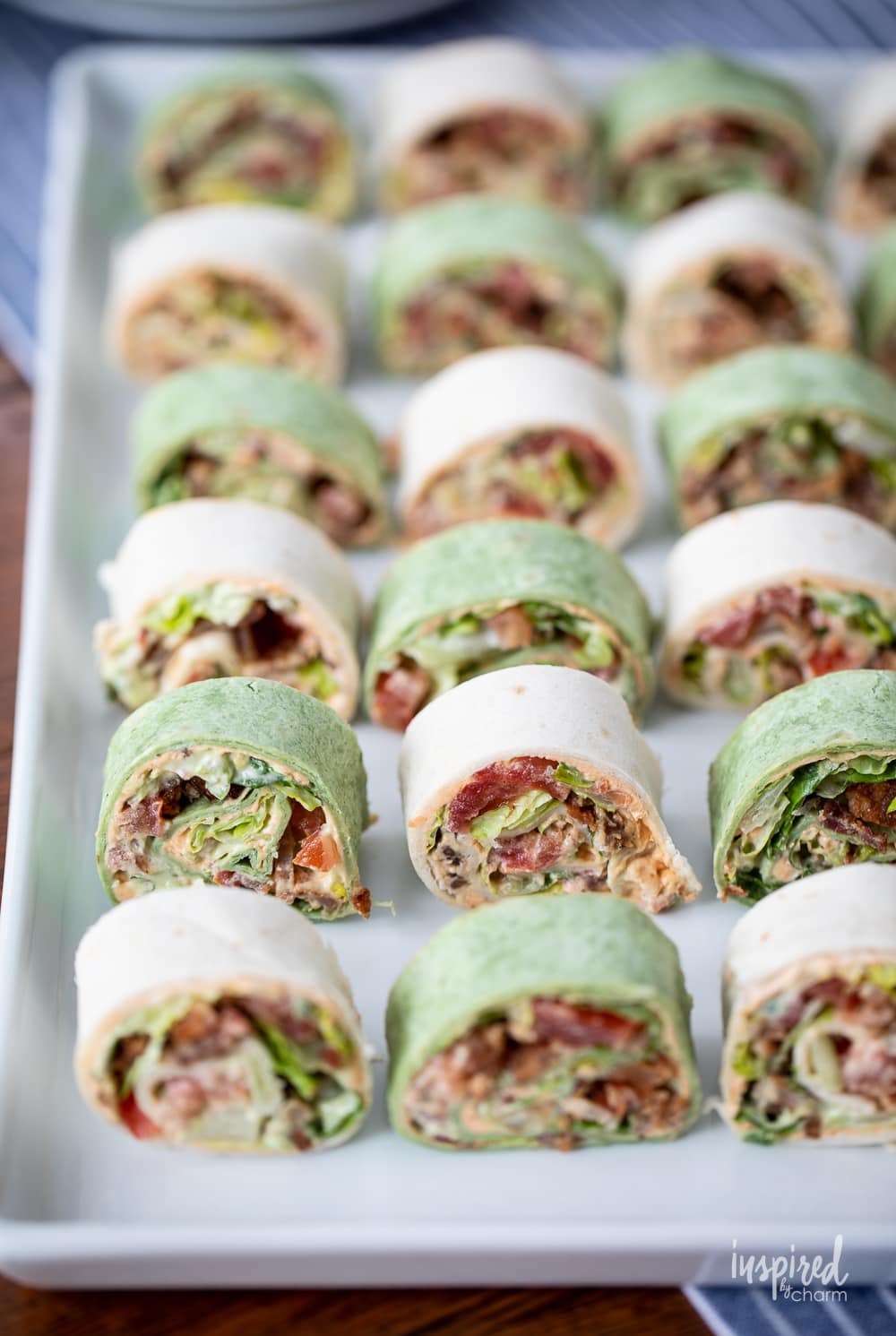 BLT Pinwheel Sandwiches lined up and displayed on a large platter.