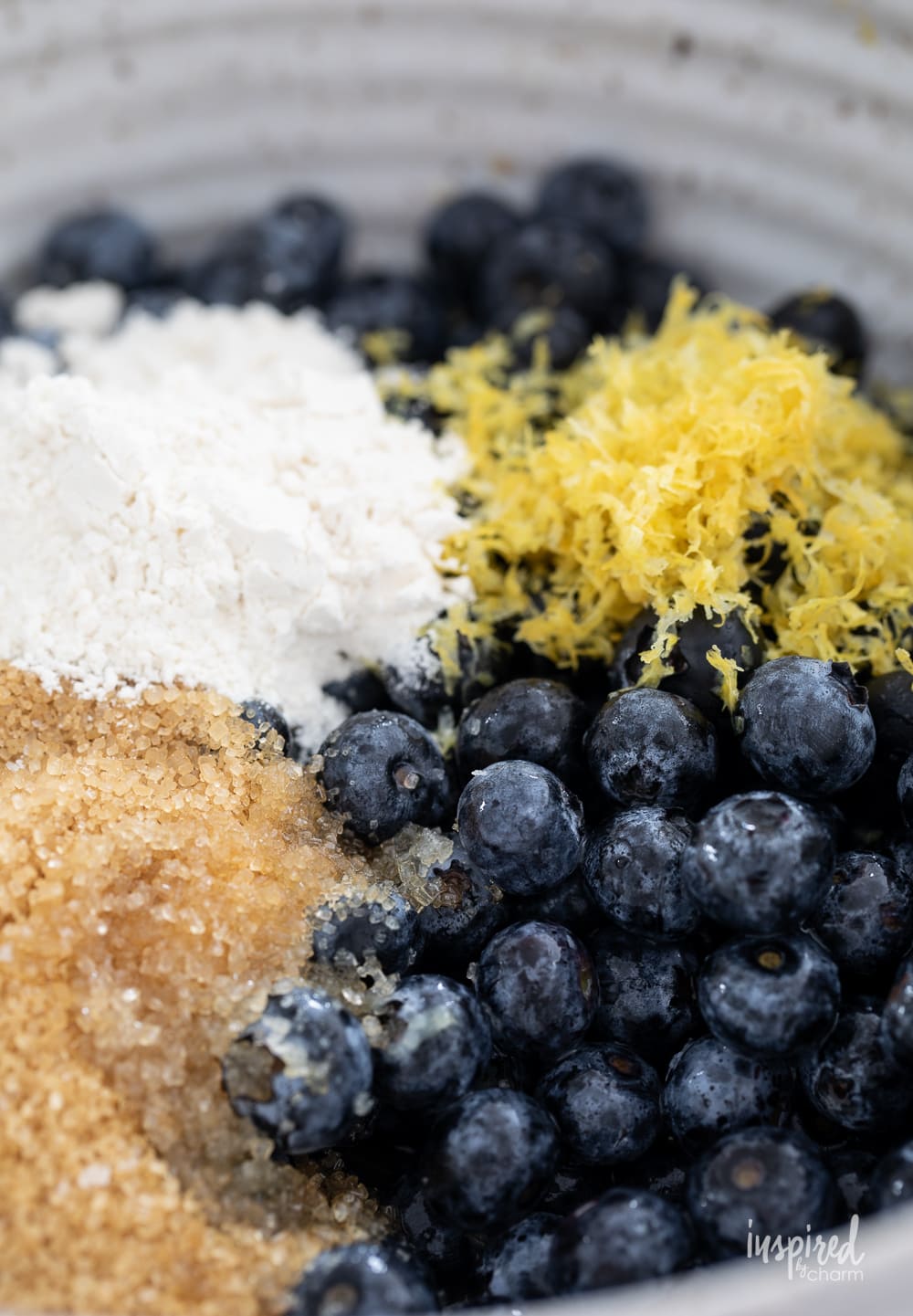 blueberries, flour, sugar, and lemon zest in a bowl.