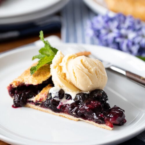 slice of blueberry galette with ice cream on a plate.