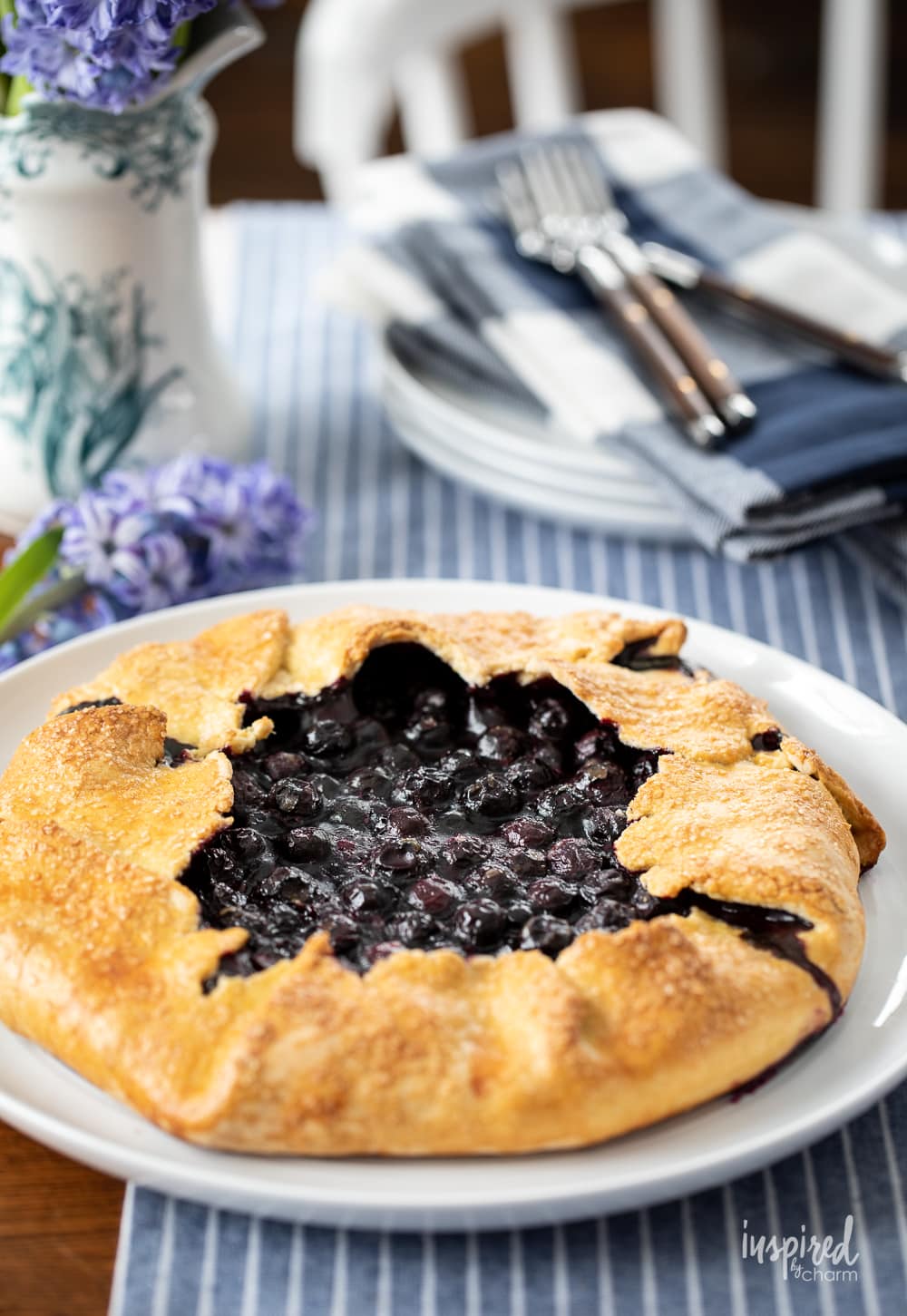 whole blueberry galette on platter on table. 

