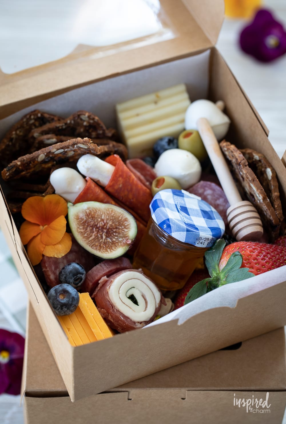 close up of a charcuterie box filled with meats, cheese, fruits, and more. 