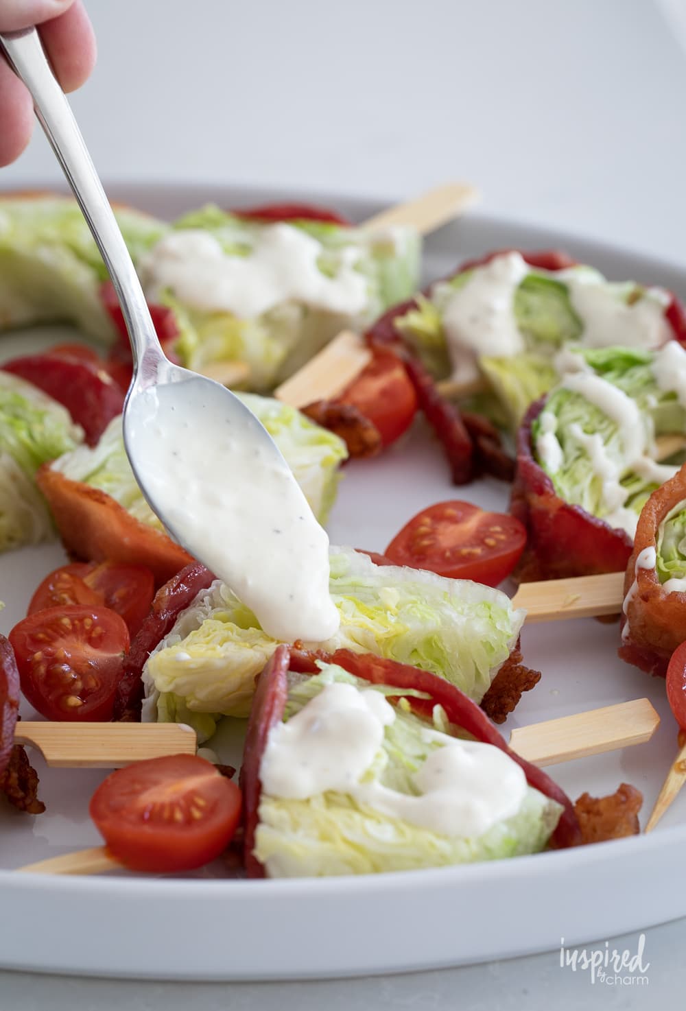 drizzling blue cheese dressing onto Wedge Salad Skewers.