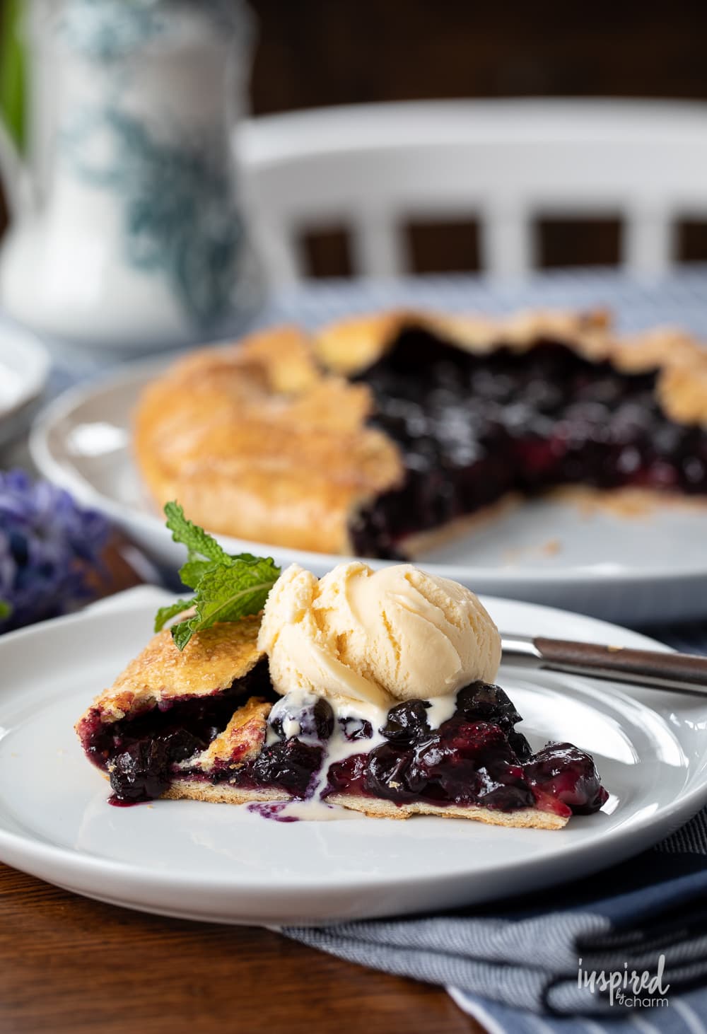 slice of blueberry galette with ice cream on a plate.