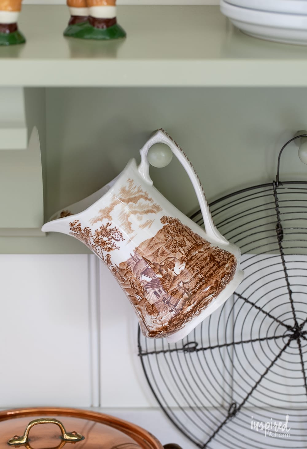transferware pitcher hanging on a peg rail in a kitchen.