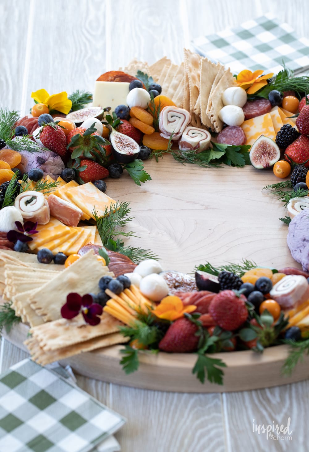 beautiful charcuterie board shaped into a circle wreath filled with meats, cheese, fruits, and crackers.