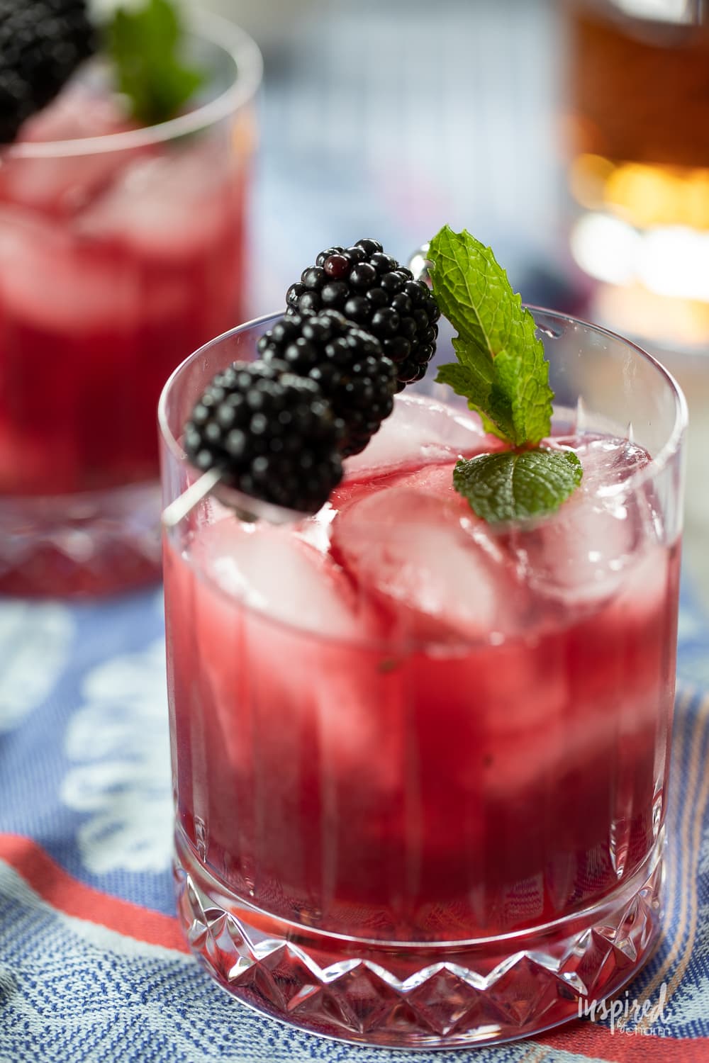 blackberry bourbon smash cocktail in a glass with blackberry garnish.