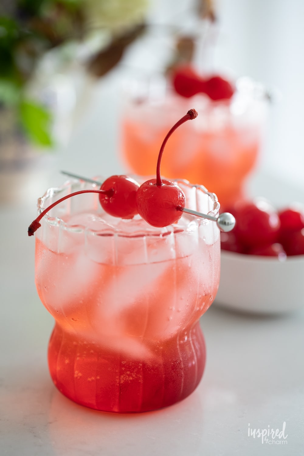 dirty shirley cocktail in glass garnished with cherries.