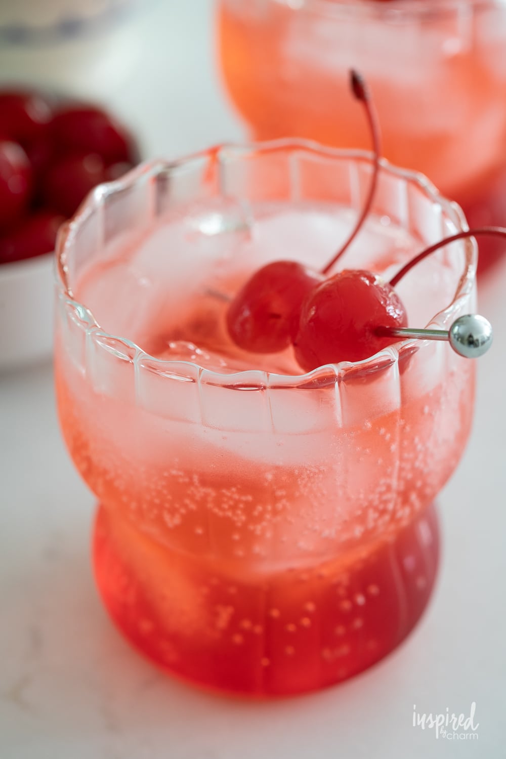 close up of cherries in dirty shirley drink garnished with cherries.