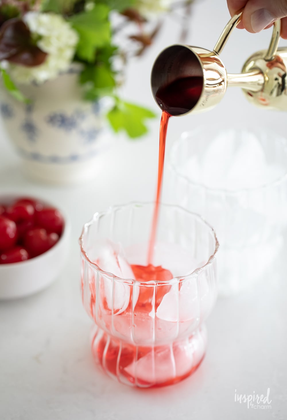 adding grenadine syrup to a glass of ice. 
