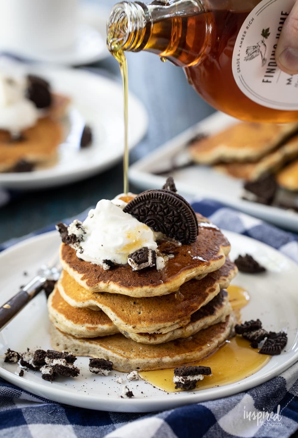 maple syrup being poured onto a stack of Oreo pancakes.