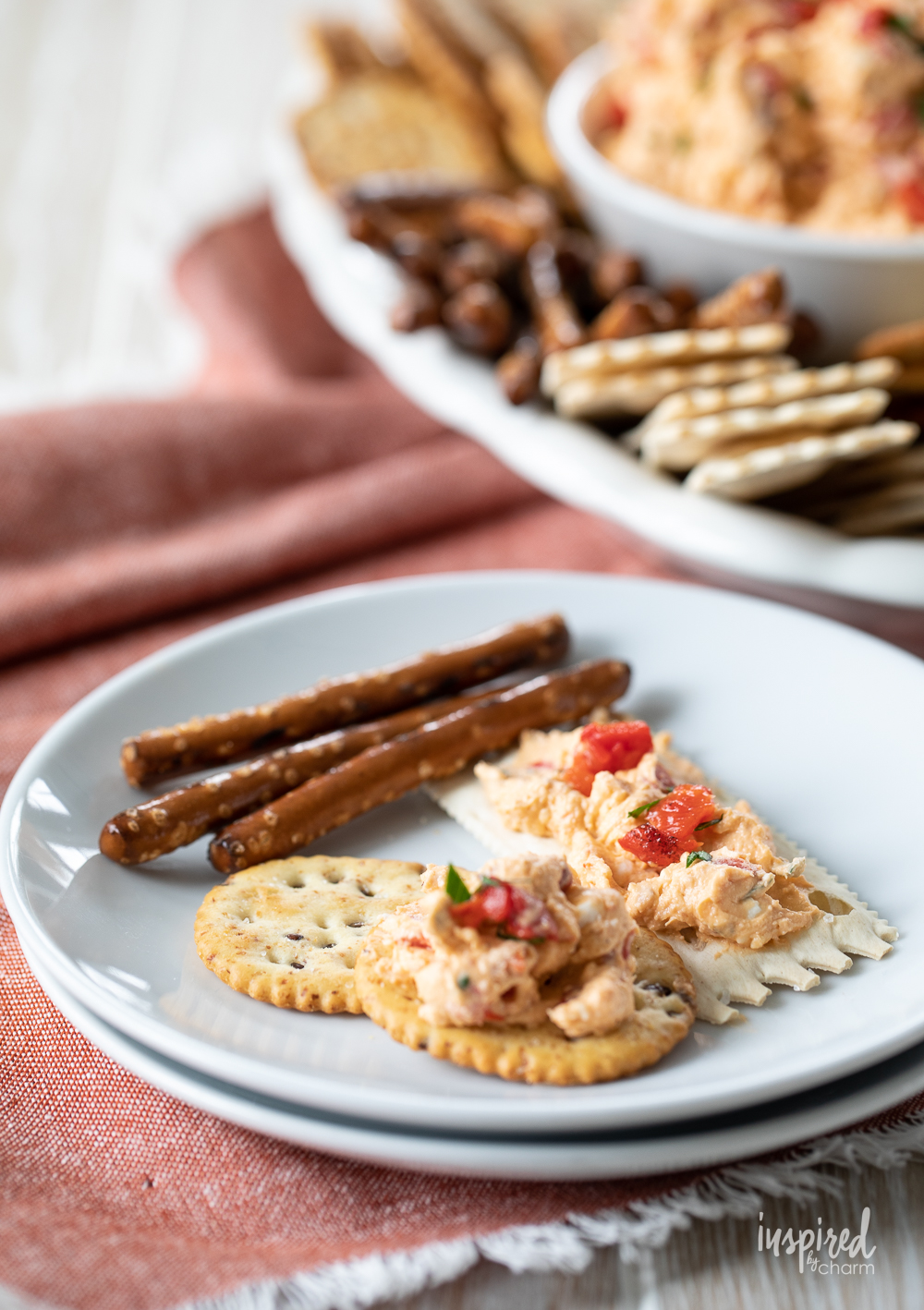 roasted red pepper dip on a plate with crackers.