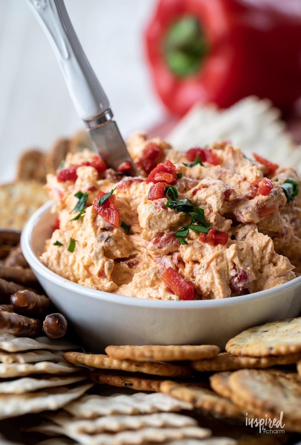 roasted red pepper dip in a bowl with crackers.