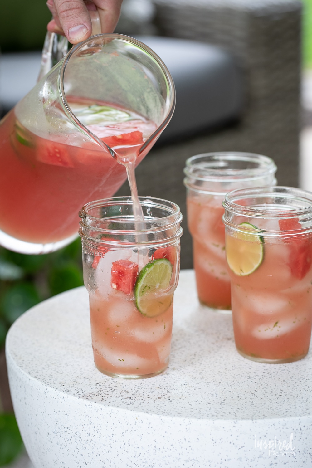 pour watermelon sangria from a pitcher into glasses filled with ice.