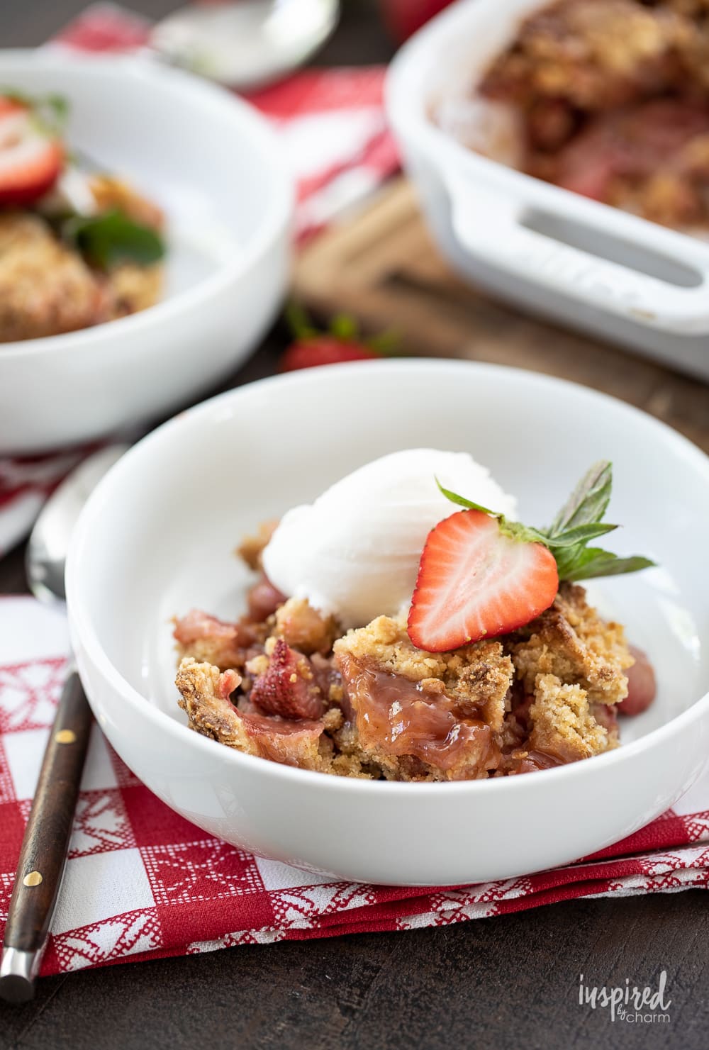 strawberry crumble served in two bowls with a scoop of ice cream.