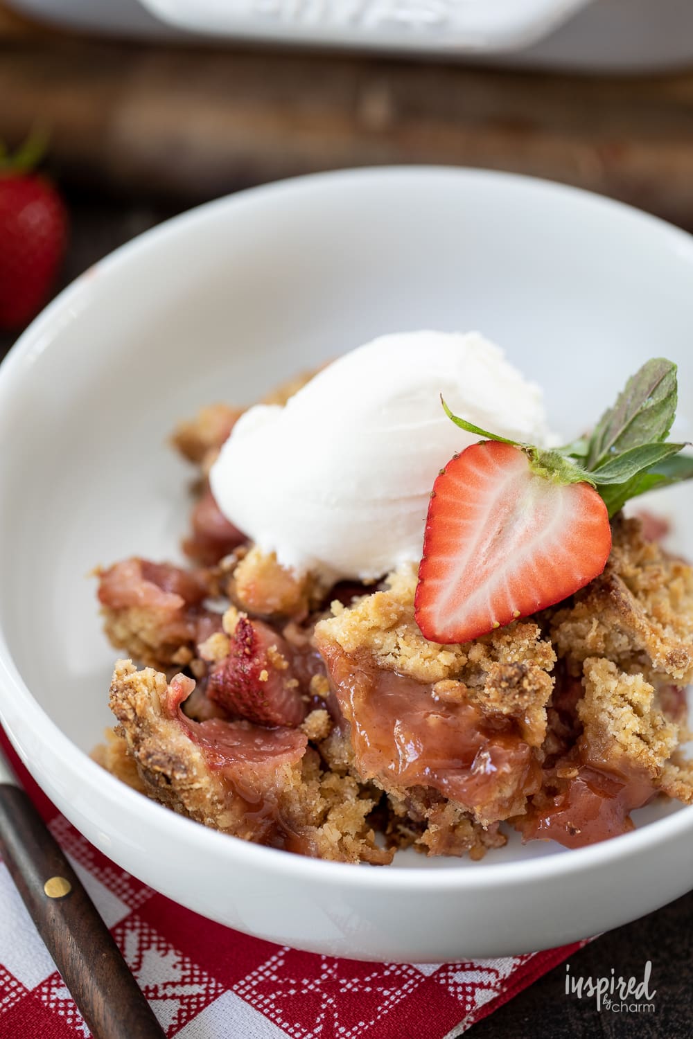 strawberry crumble served in two bowls with a scoop of ice cream.