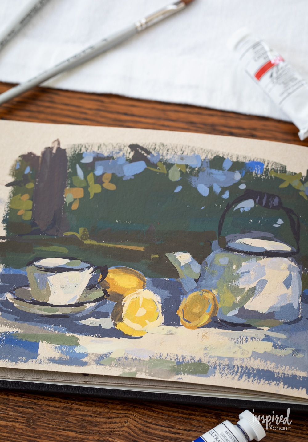 gouache painting of a teapot, teacup, and lemons.