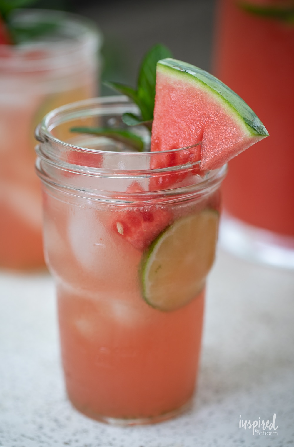 close up of watermelon sangria in a mason jar glass with watermelon wedge garnish.