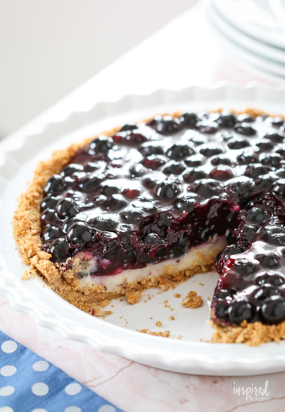 blueberry cream pie in a pie dish with a slice taken out. 