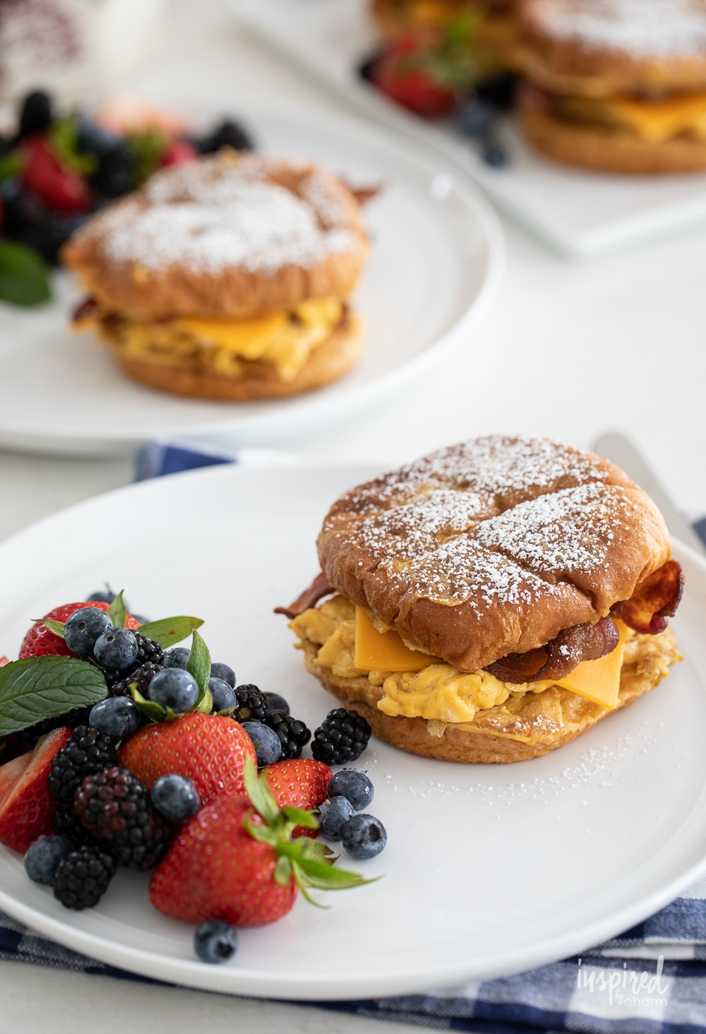 french toast breakfast sandwiches on plates on gingham napkins.