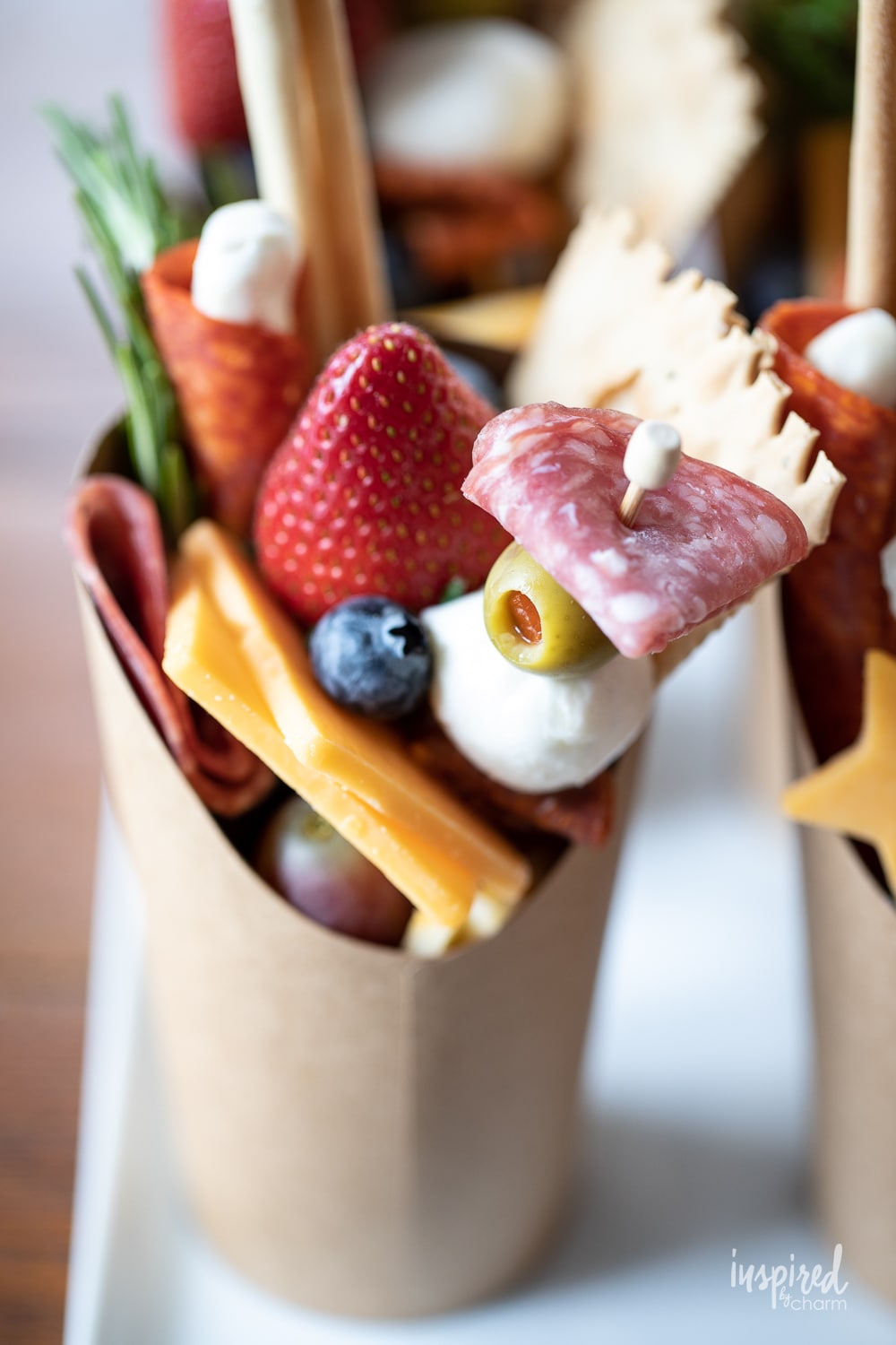 cheese, meats, and fruits stacked into a charcuterie cup.