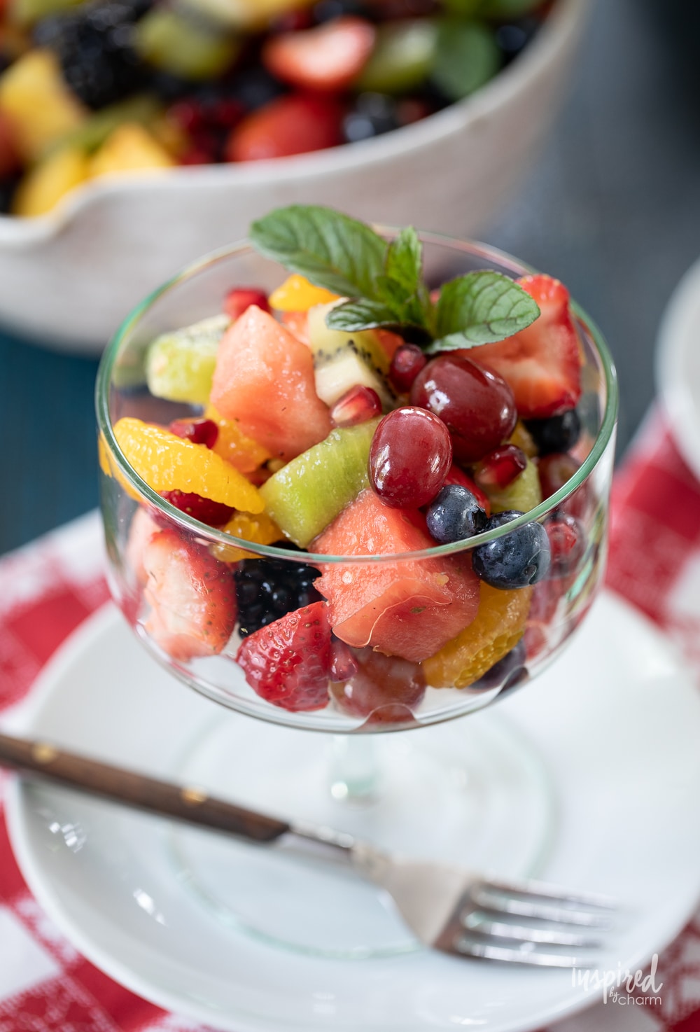 up close photo of fruit salad in a clear glass serving dish.