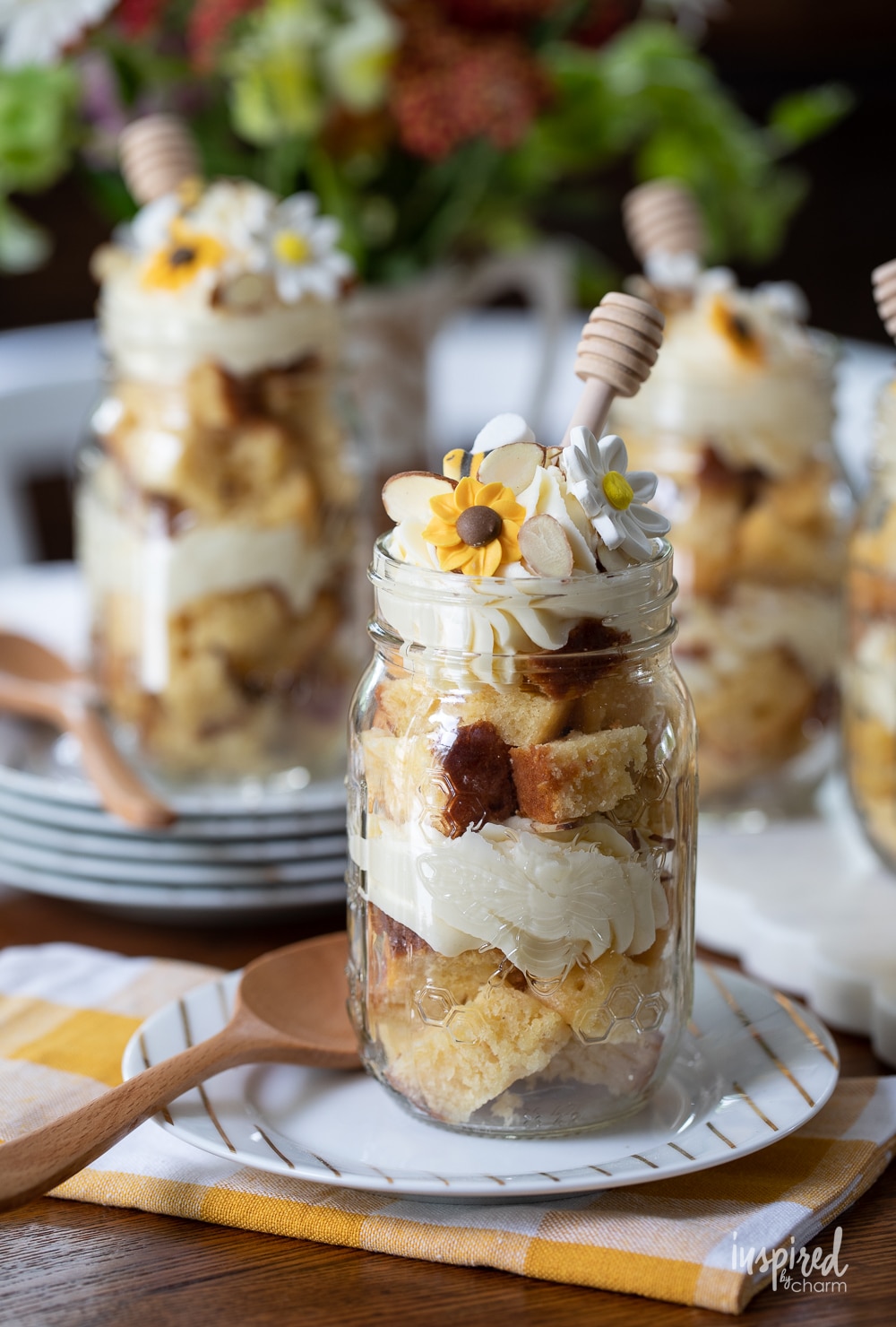 honey cake in mason jar layered with frosting and topped with edible flowers.