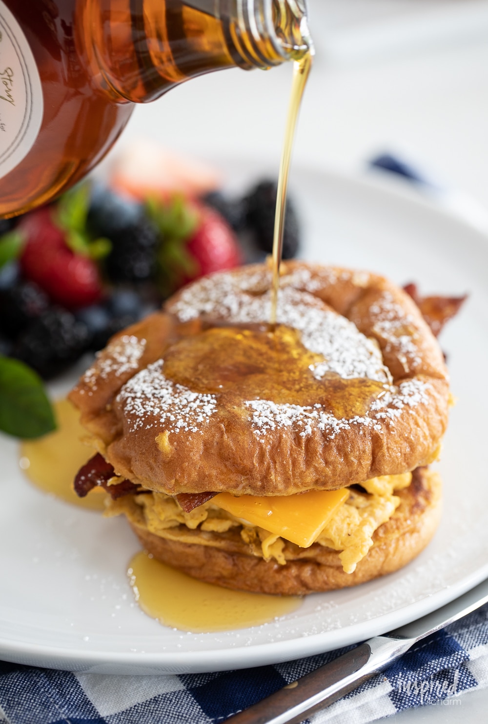 pouring maple syrup on french toast breakfast sandwiches.