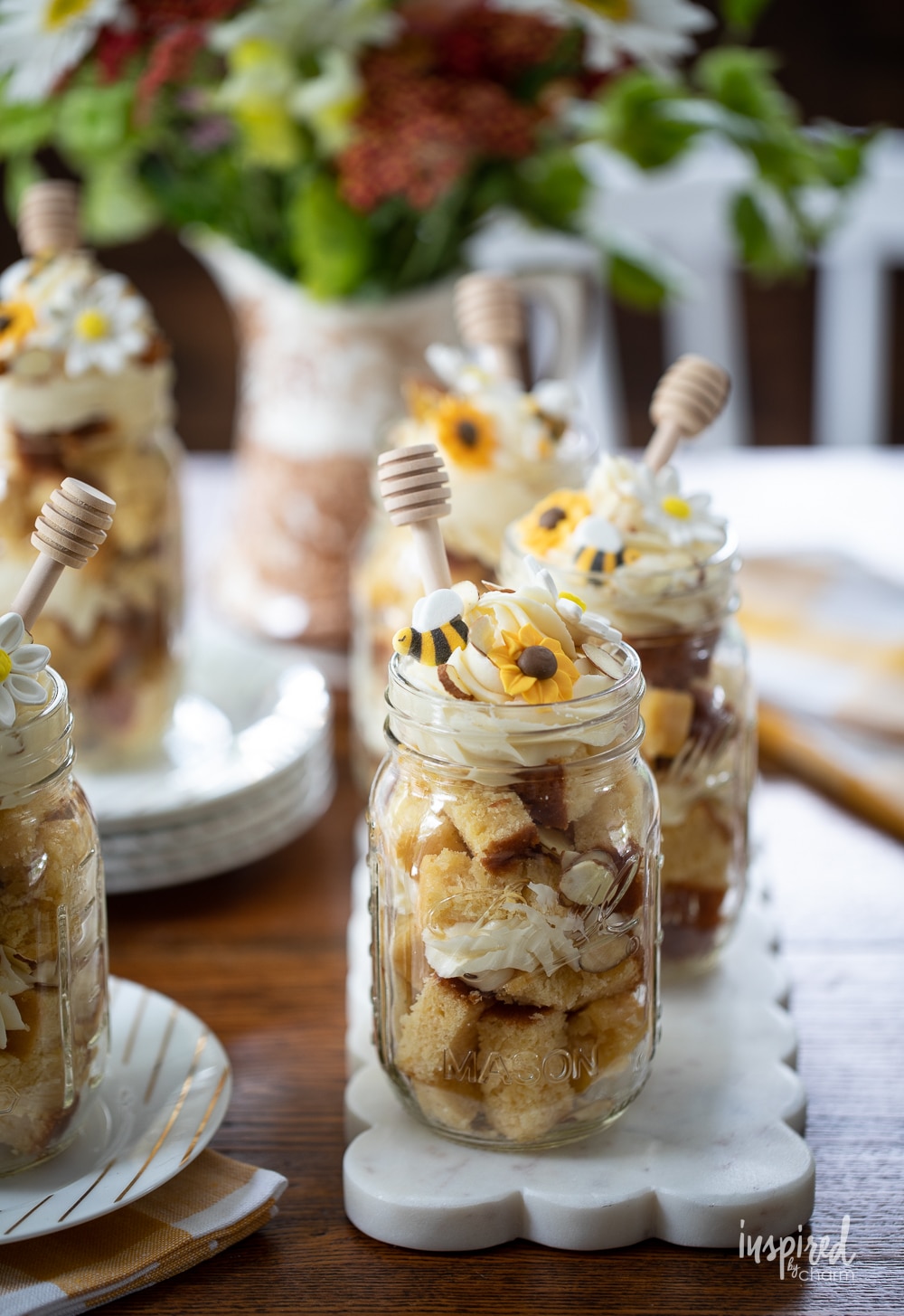 mason jar honey cakes lined up on a marble board on a table.