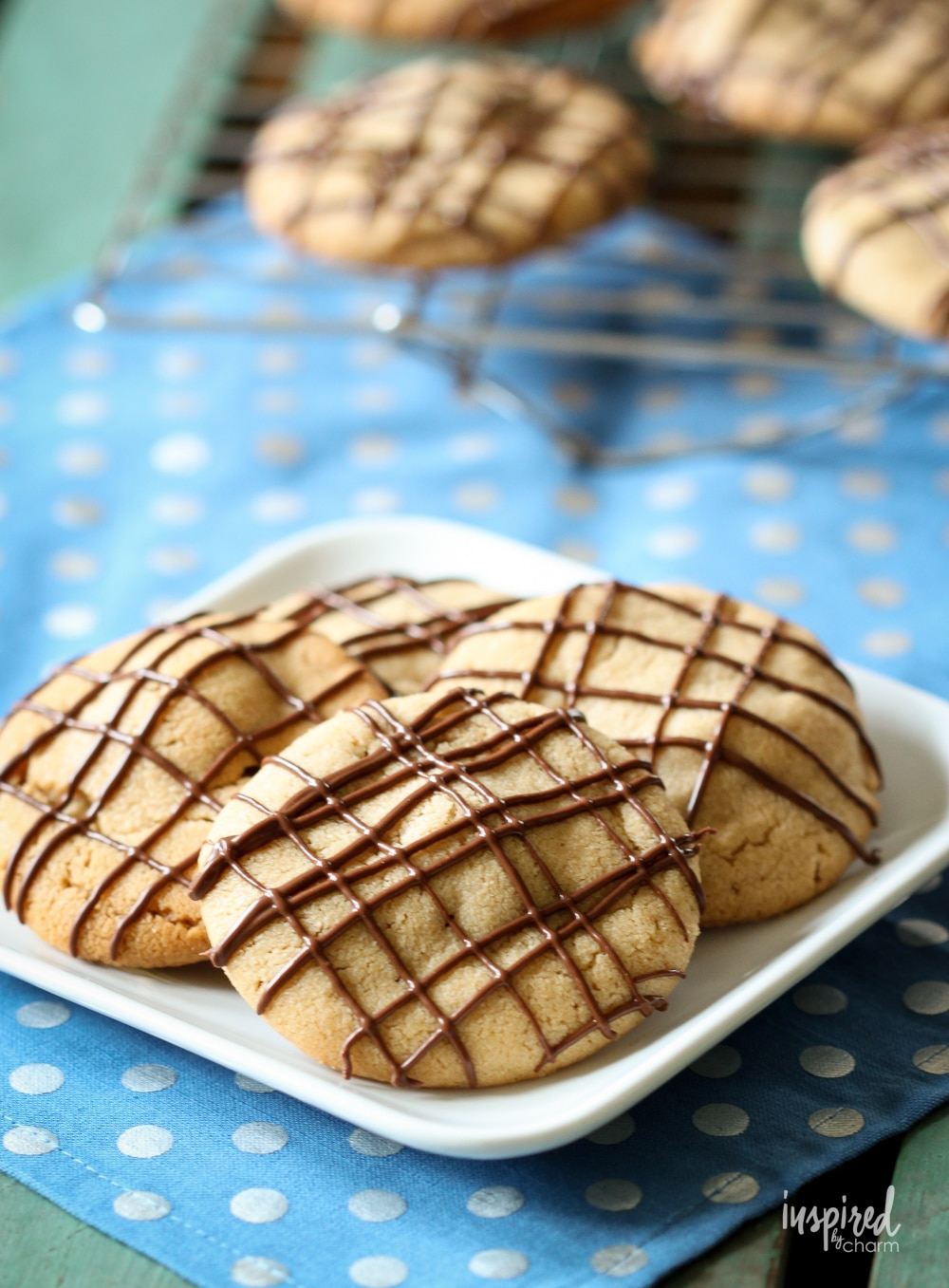 stuffed peanut butter cookies on a plate on a blue polka dot napkin.