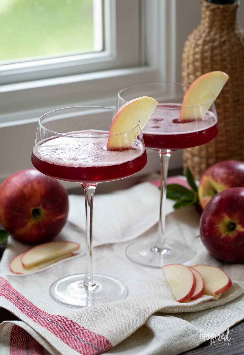 two washington apple cocktails in martini glass with apple garnish.