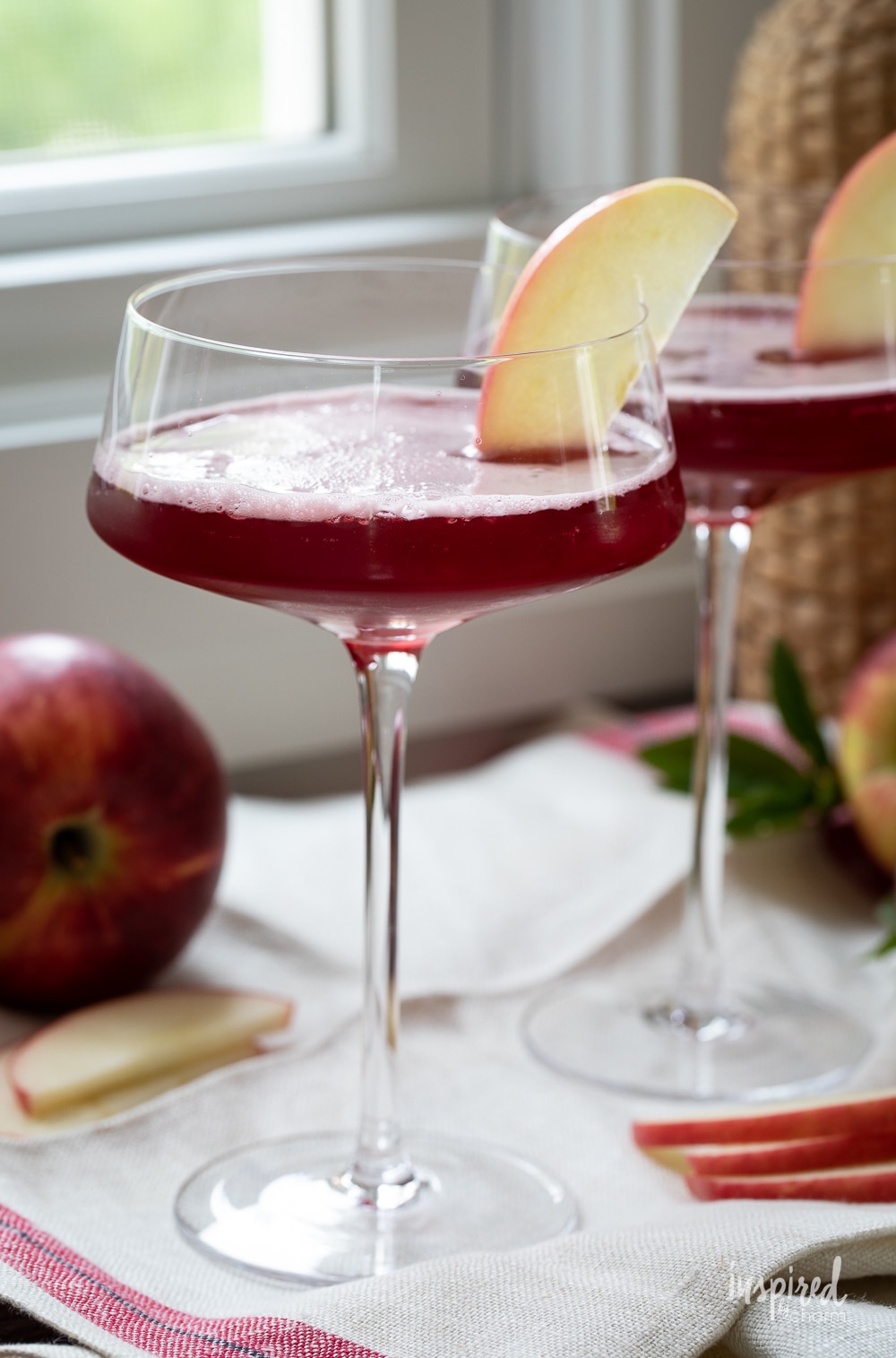 washington apple cocktail in martini glasses with apple slice garnish.