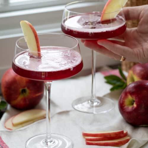 hand holding washington apple cocktail in martini glass.