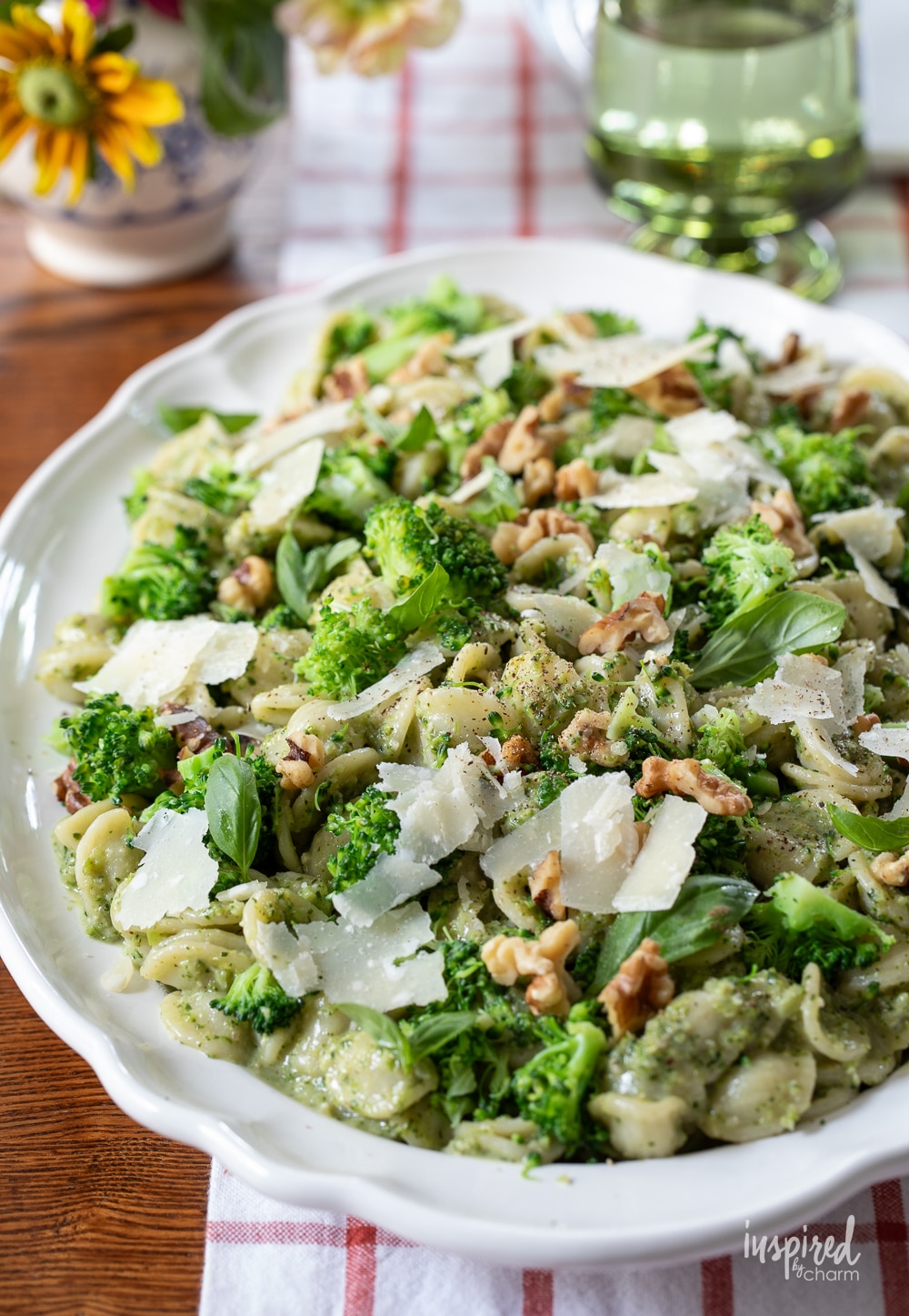 a big platter of broccoli pesto pasta salad on a table.