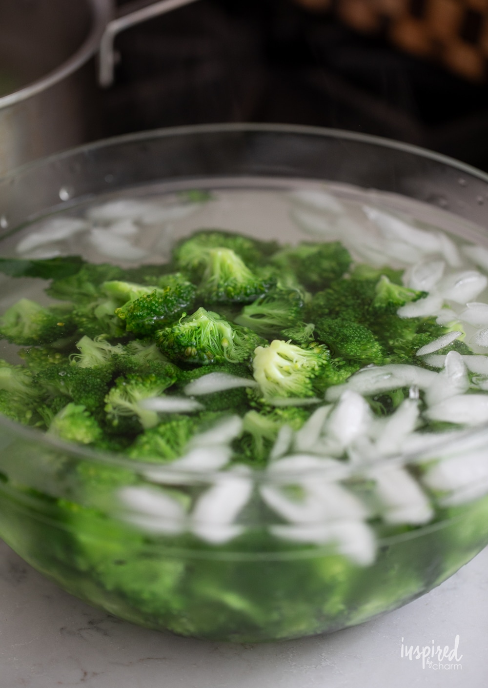 cooked broccoli in an ice bath in a bowl.
