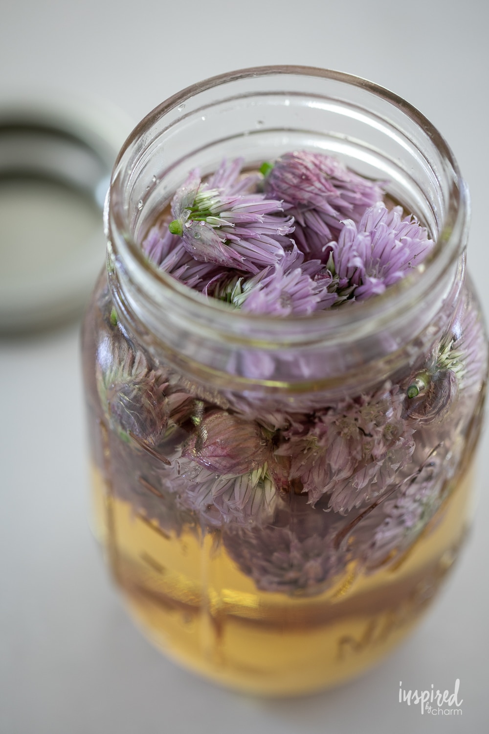 open jar of chive blossom vinegar.