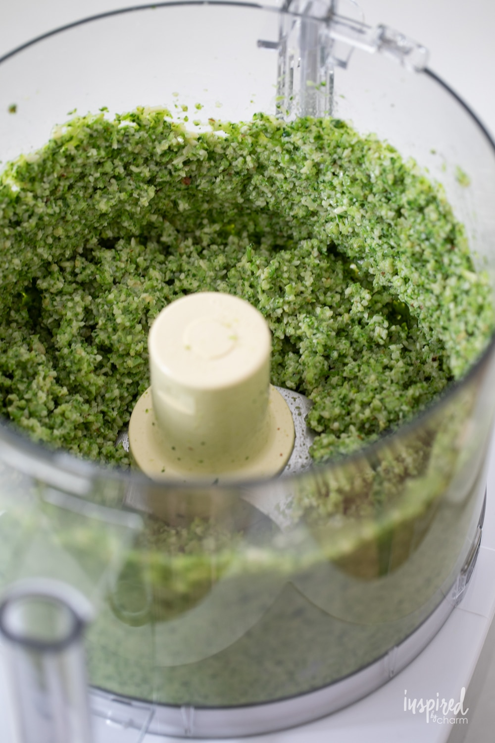 broccoli pesto in a the bowl of a food processor with the lid off. 