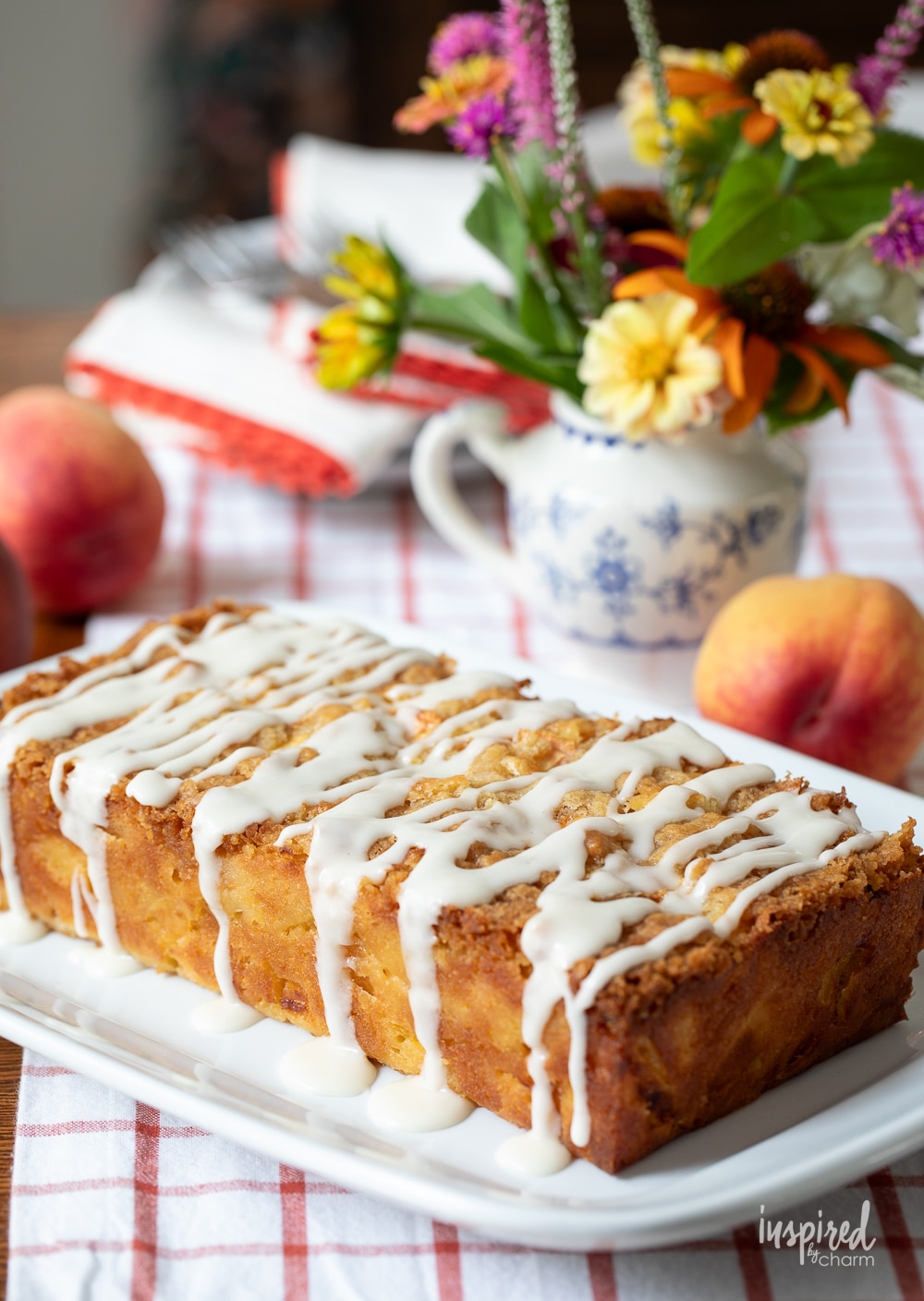 loaf of peach cobbler pound cake on a white dish.