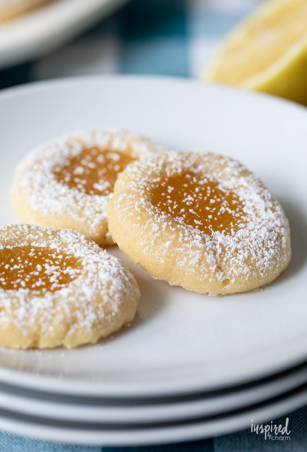 close up of three lemon curd cookies on a plate.