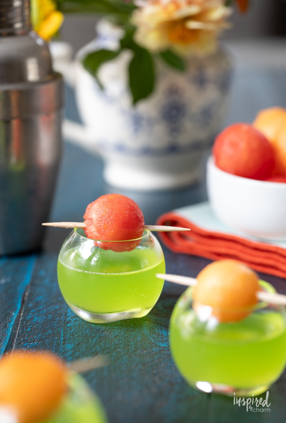 melon ball shot in small glasses with melon garnish on top. 