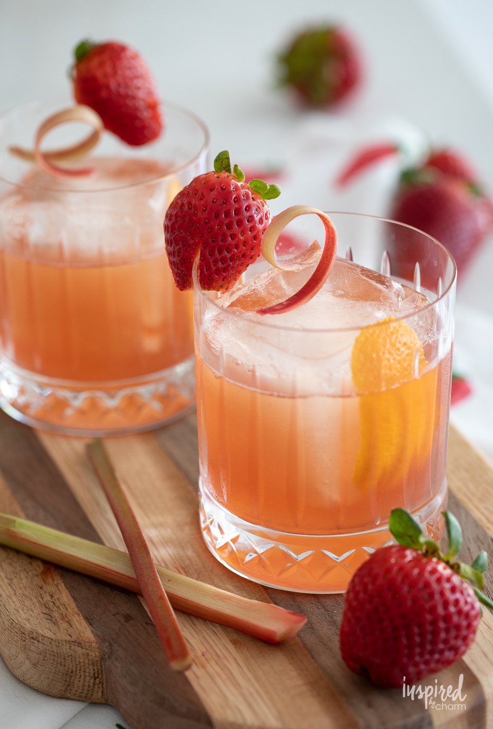 strawberry rhubarb old fashioned in glasses with strawberry garnish.