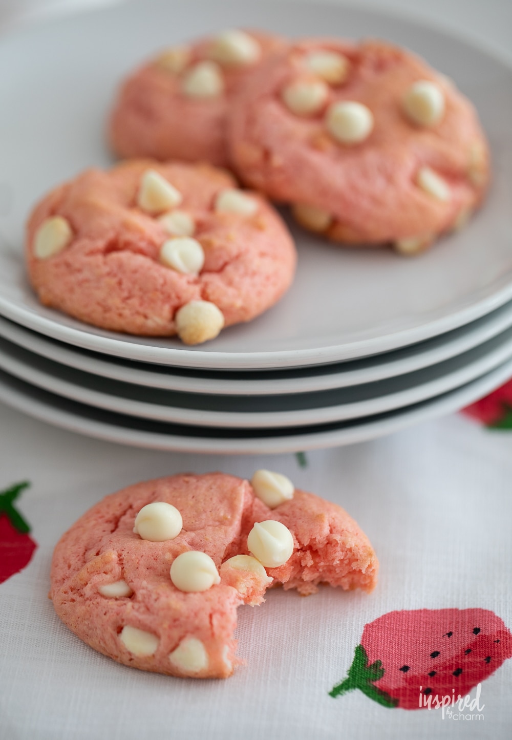 strawberry cake mix cookies on a small plate with one that has a bite removed. 