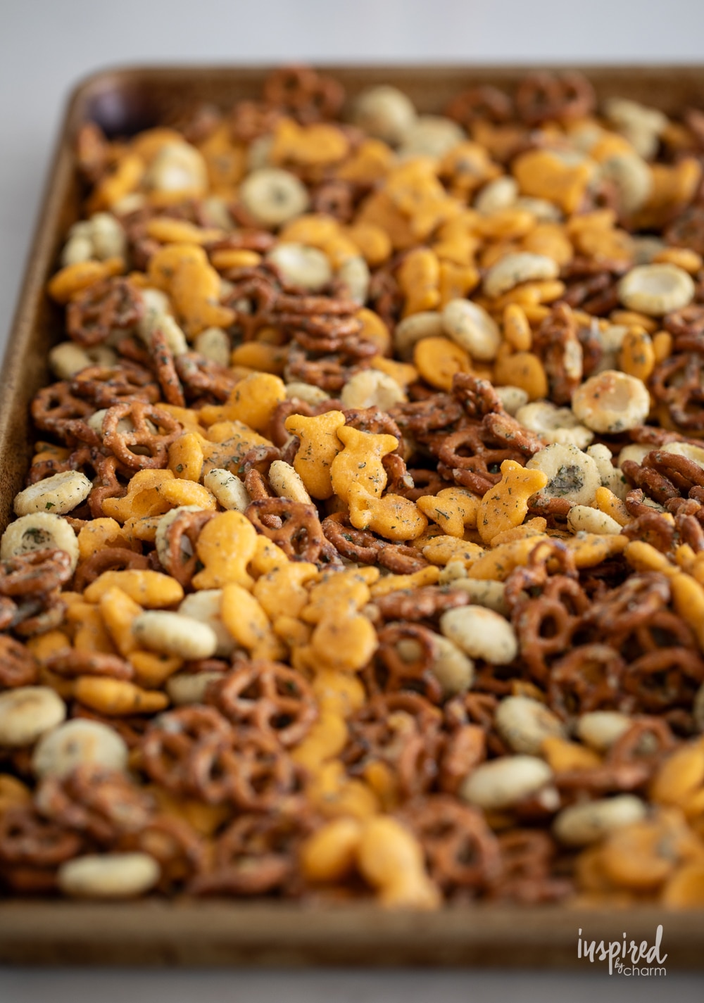 ranch pretzel snack mix spread out on a baking tray.